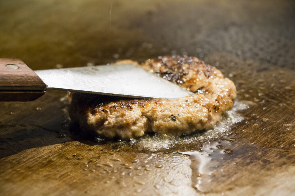 鉄板でハンバーグを焼く調理風景